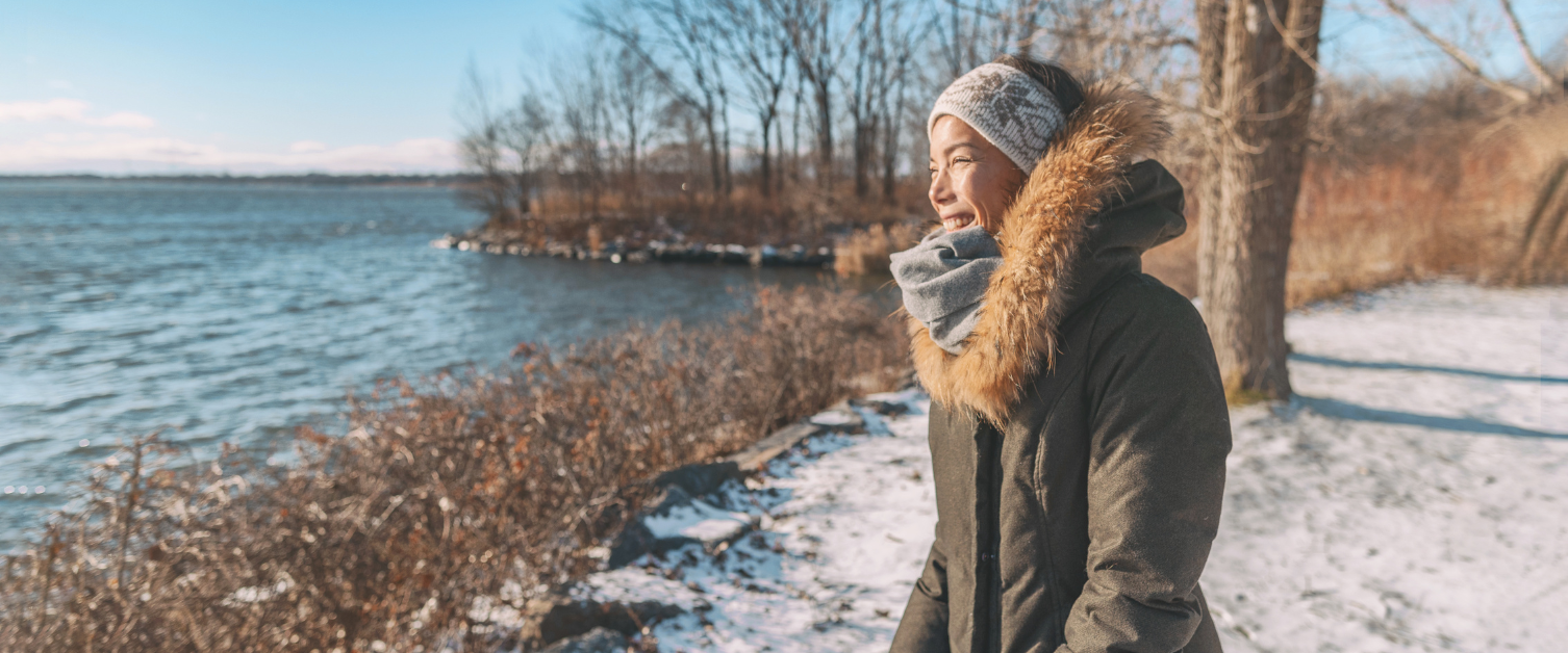 Image of smiling woman wearing coat and scarf outside in the snow