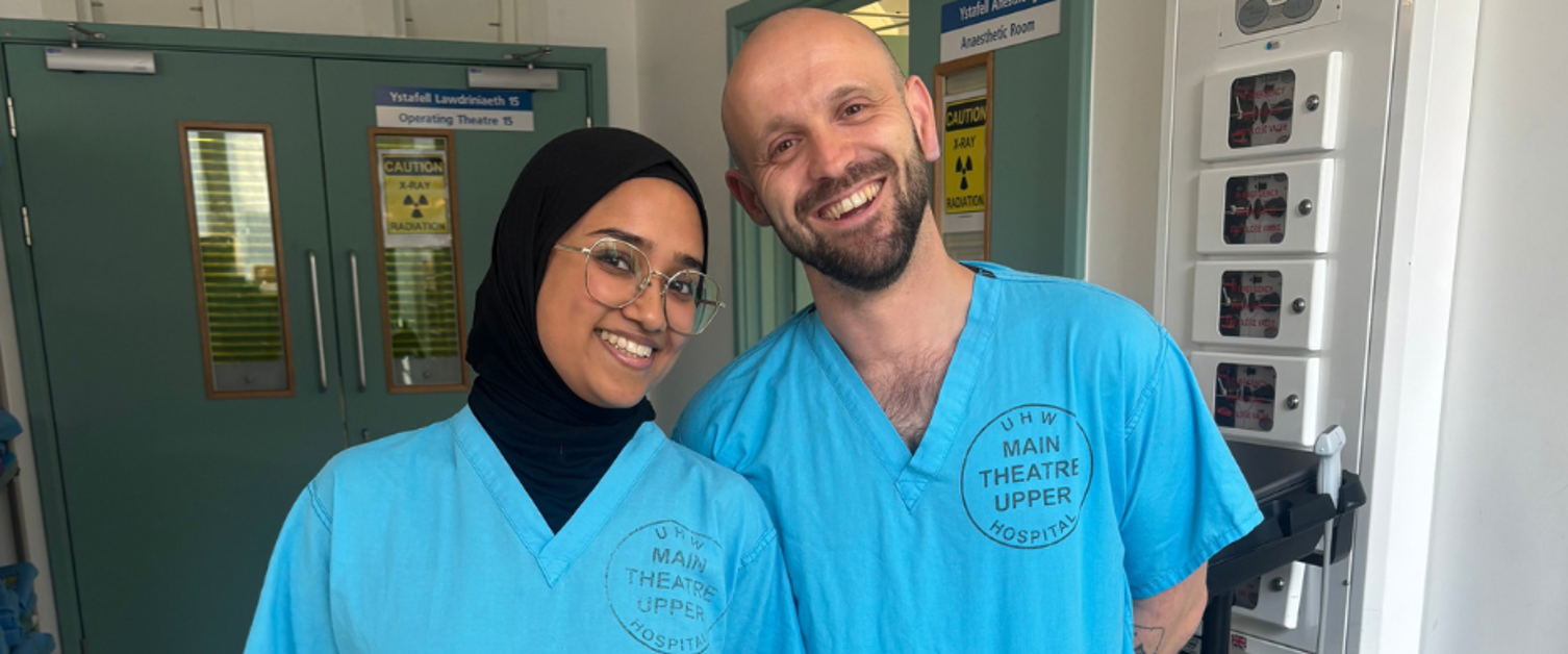 Tahsin and James photographed in blue scrubs at Theatres in the University Hospital of Wales