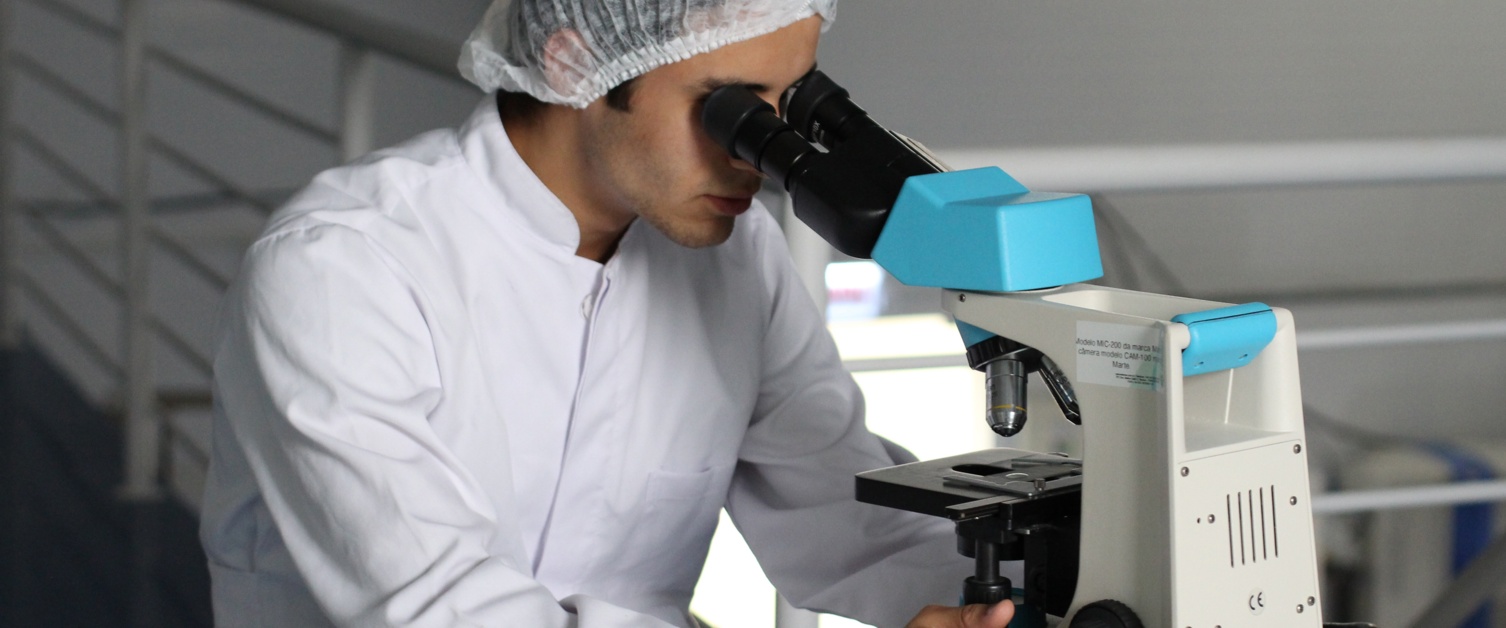 Man looking down a microscope.