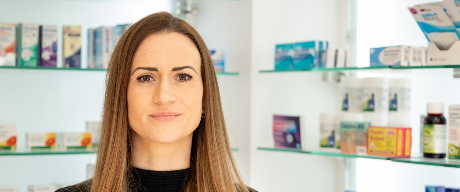 An image of a Pharmacist smiling in a Community Pharmacy in Cardifff