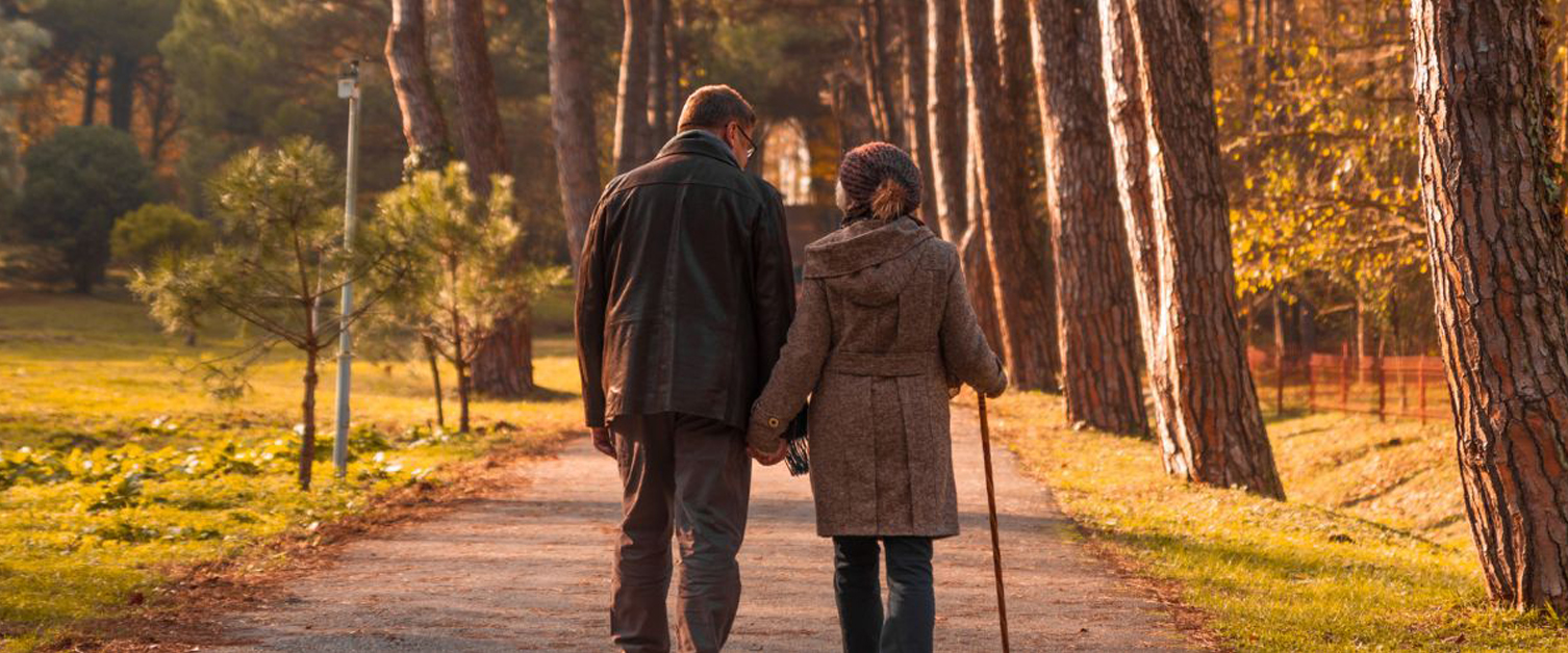 a couple walking through the trees in autumn