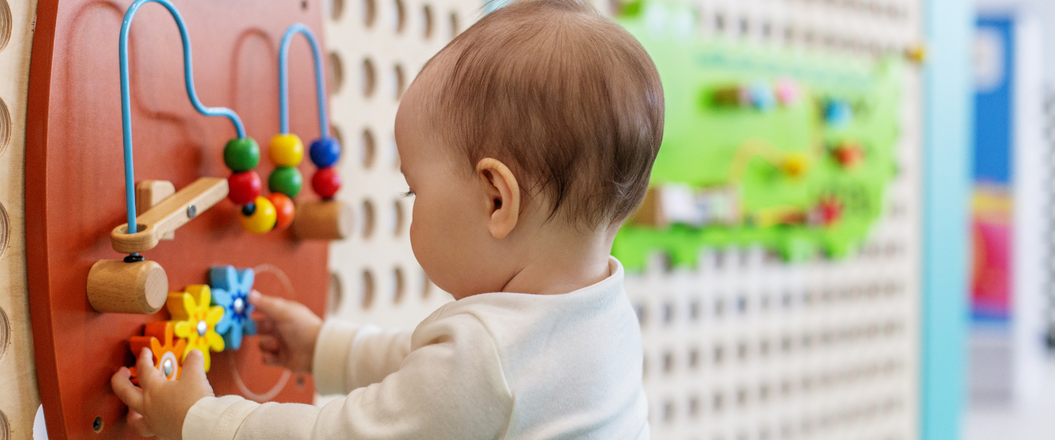 Young child playing with activity wall