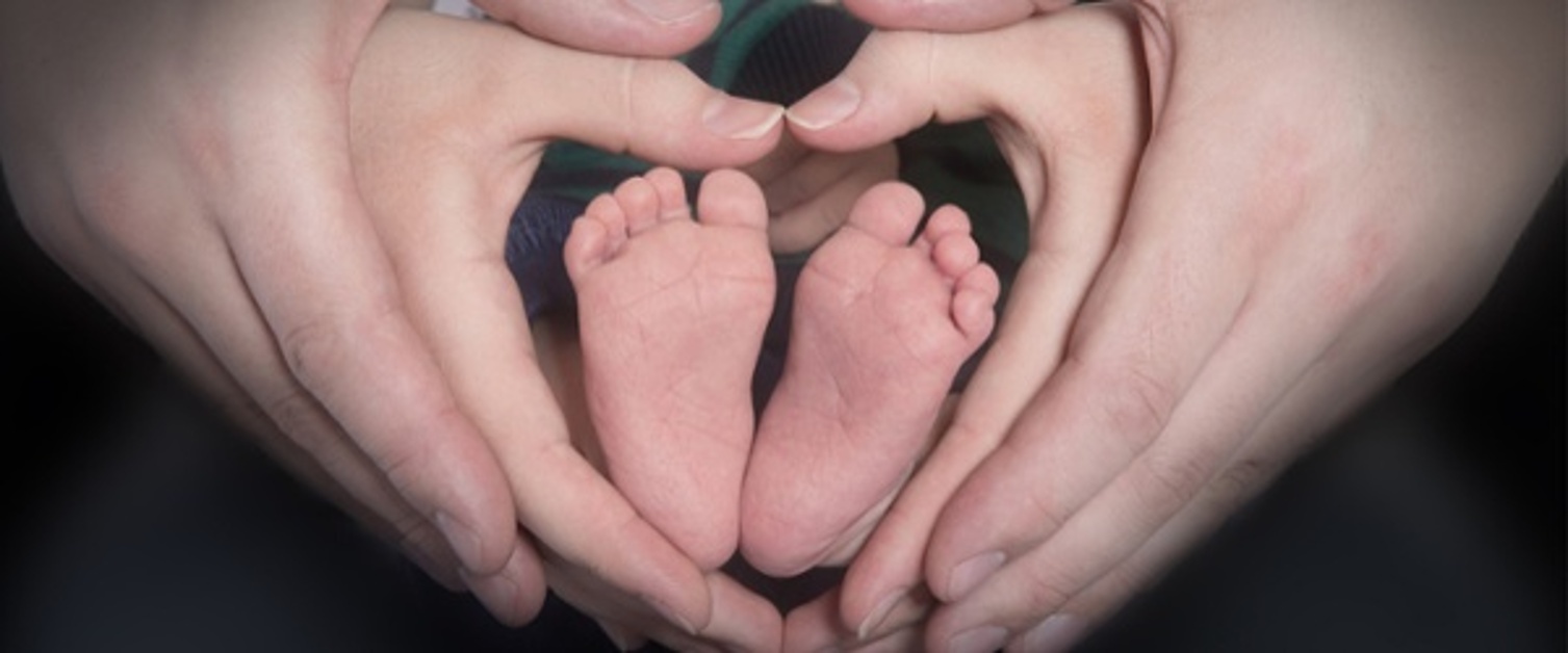 Parent with hands around baby