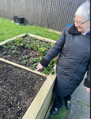 Julie (Resident) with the strawberries and garlic