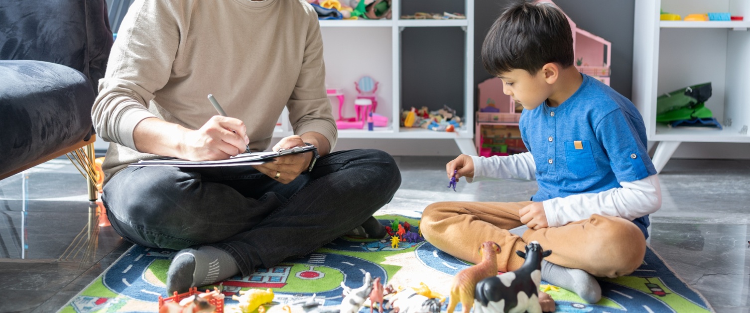 Child playing with person making notes