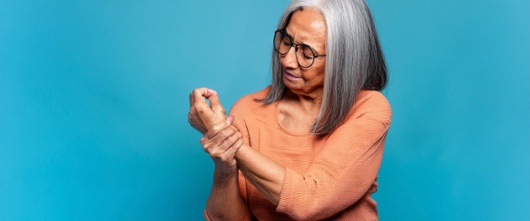 elderly woman holding wrist