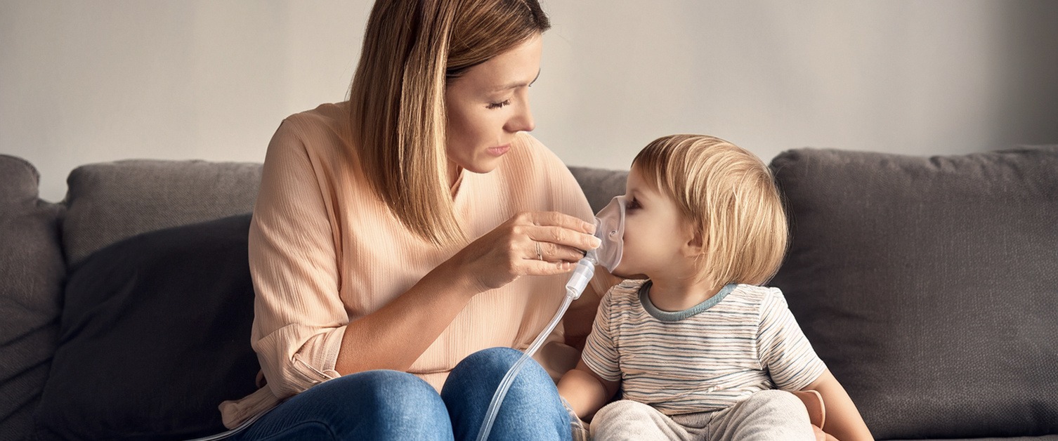 mother holding oxygen mask on a child