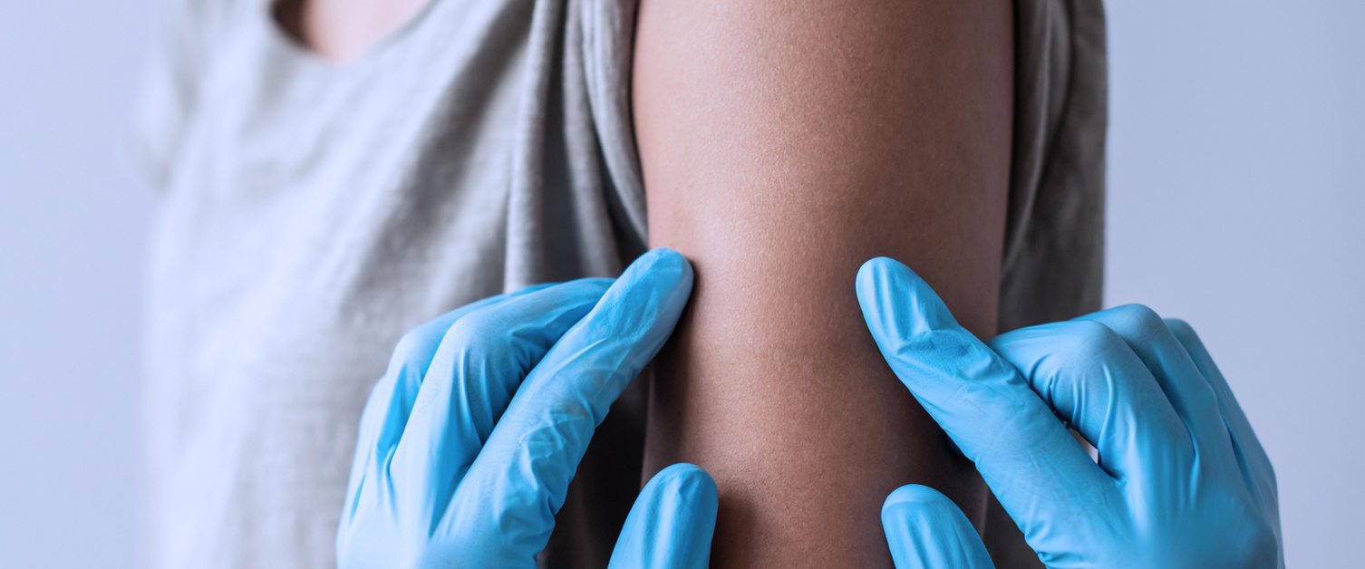 Nurse searching for vein to administer immunisation/vaccine