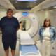 Two CTM UHB patients standing next to Lung Health Check scanner