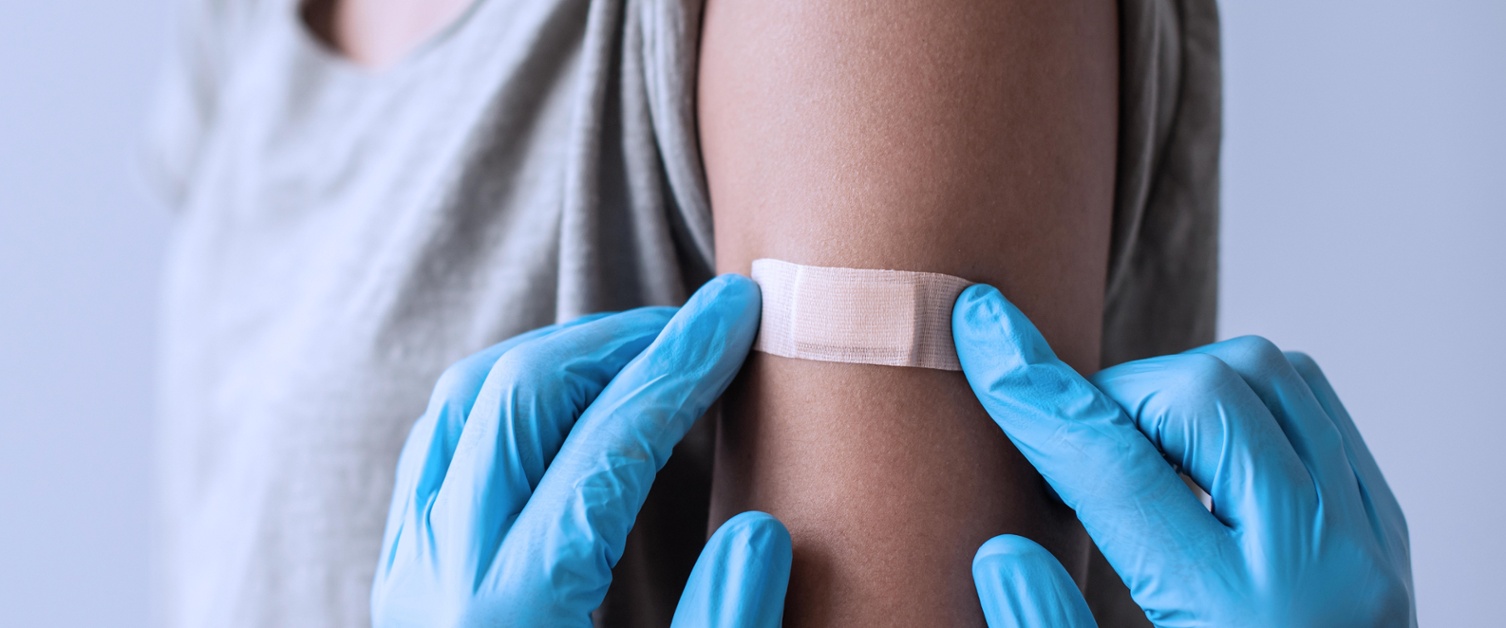 Nurse putting a plaster on after a vaccination