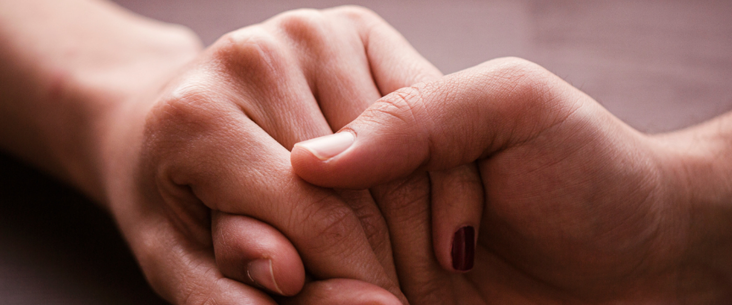 Two hands holding one another