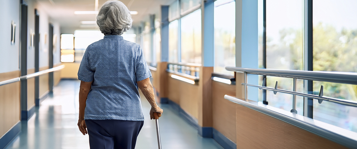 elderly woman walking through a hospital corridor