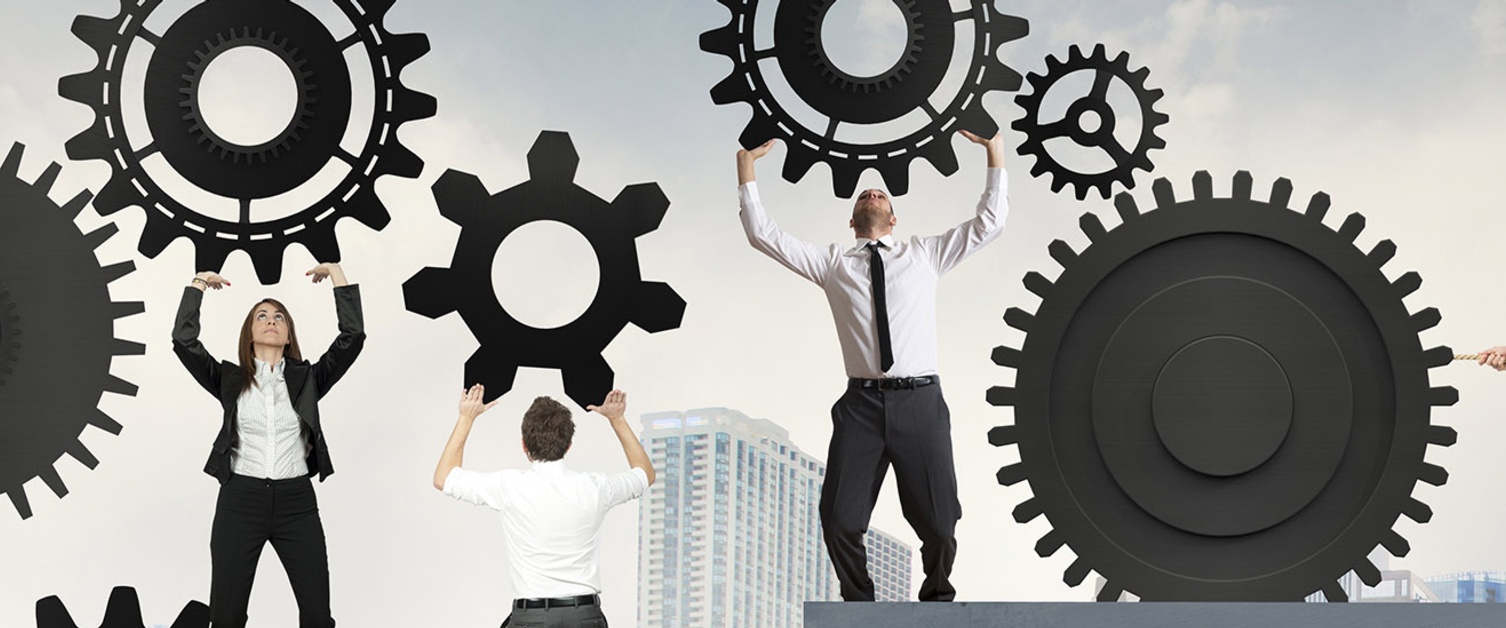 Staff lifting up gears banner