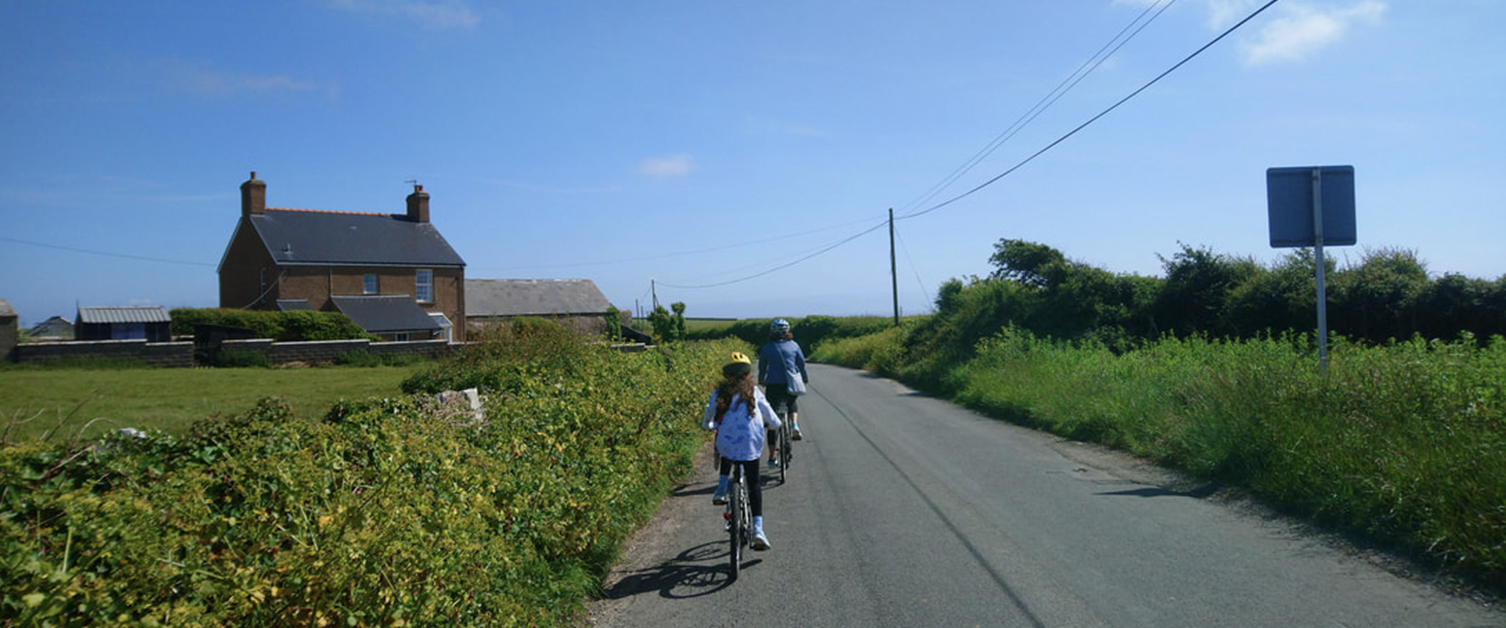 People cycling down a country lane