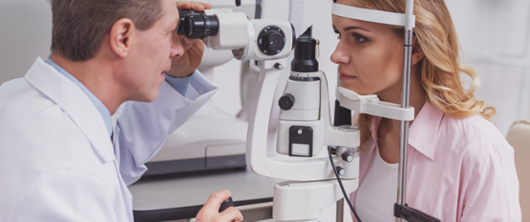 Optometrist looking at patient's eyes