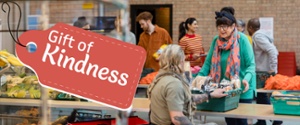 Gift of Kindness Banner - Woman gifting food to another person