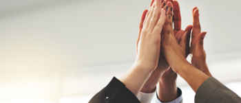 Several hands high fiving one another