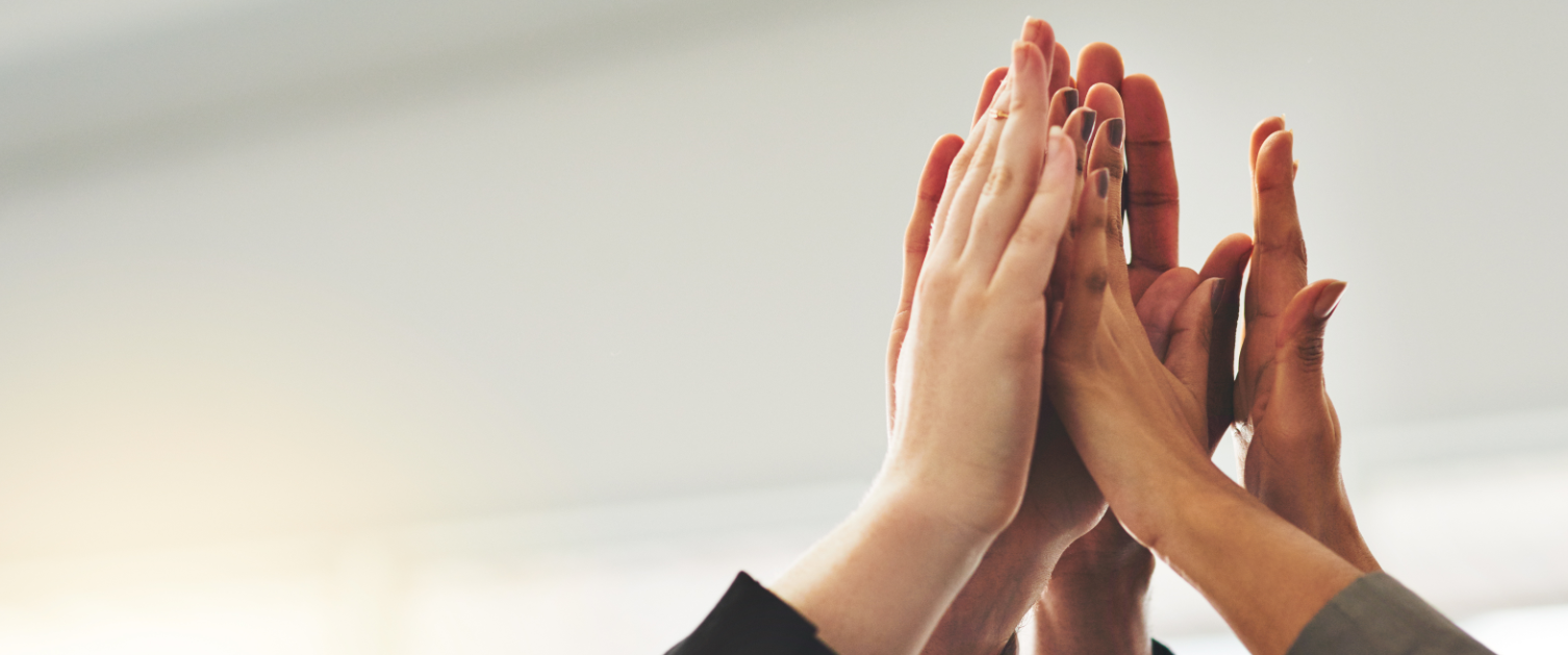 Several hands high fiving one another