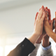Several hands high fiving one another