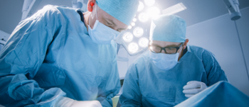 Two people operating on patient