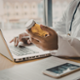Doctor holding medication whilst using laptop