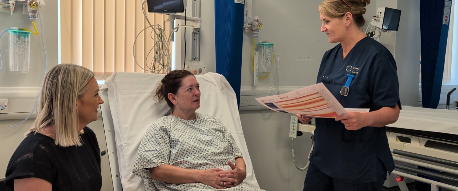 woman in hospital bed with consultants