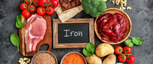 Iron on chalkboard with food surrounding it