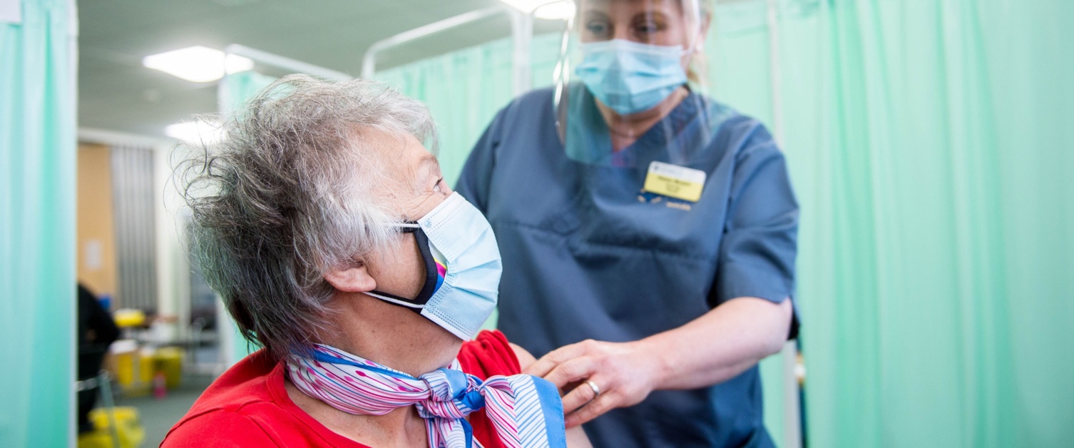 Nurse administers elderly patient COVID vaccination