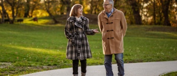 Two people chatting while walking in the park