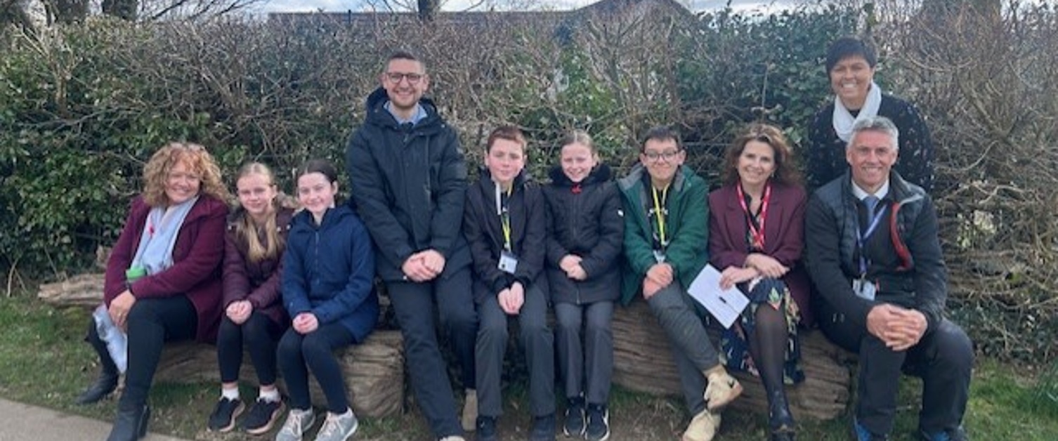 Group of staff and students sitting outside school