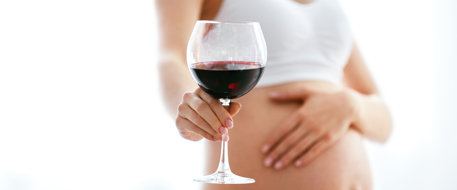 pregnant person holding wine glass