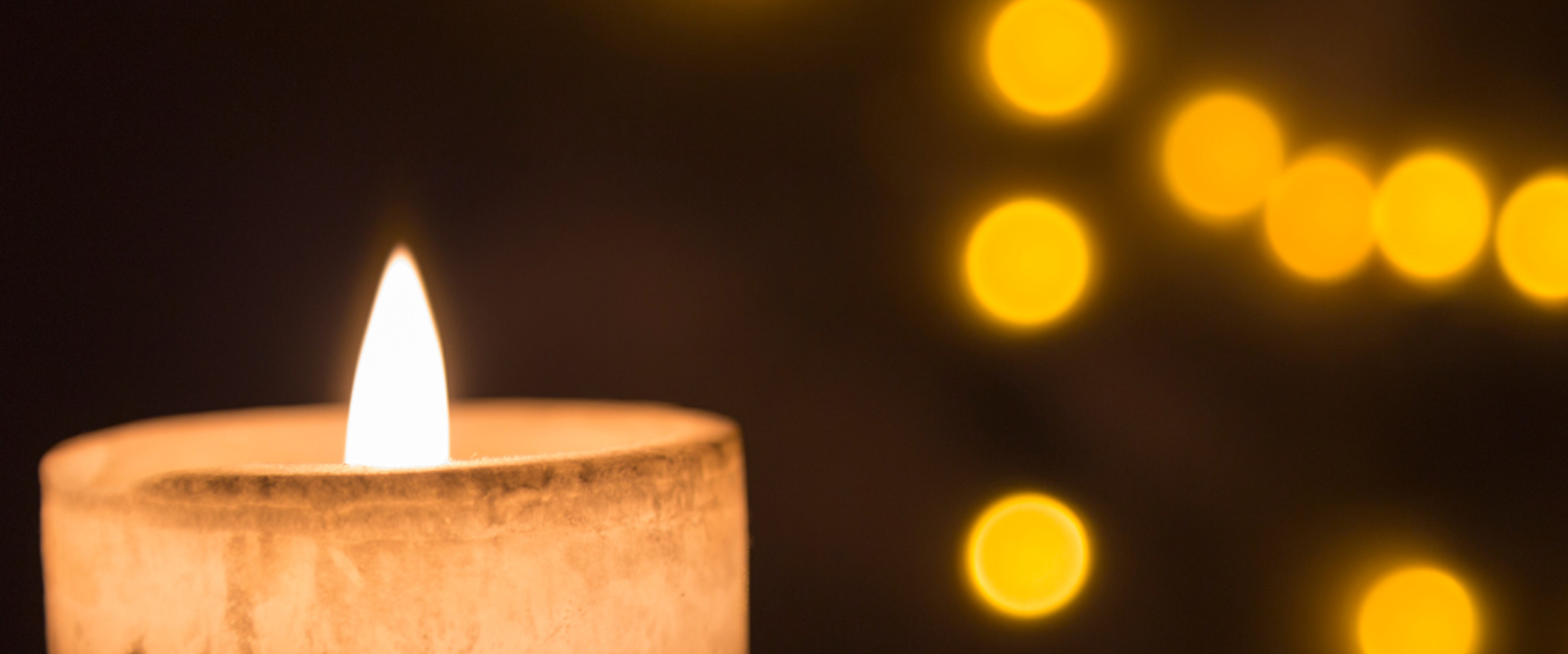 Single lit candle against a dark background