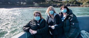 3 nurses on a boat to Caldey Island to deliver the second round of vaccines