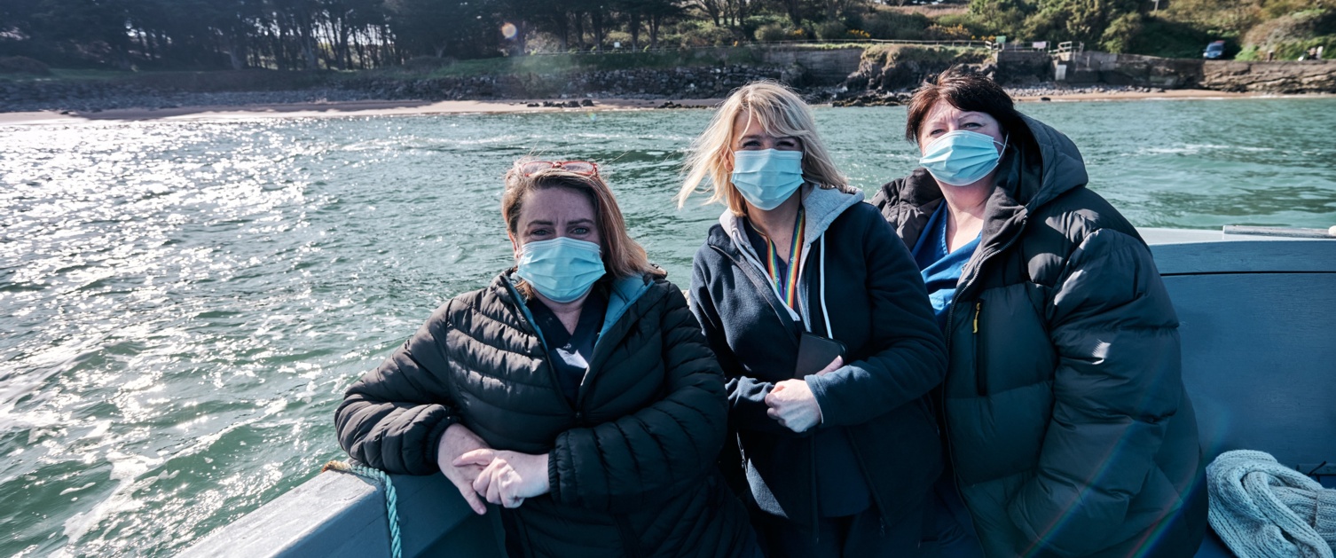 3 nurses on a boat to Caldey Island to deliver the second round of vaccines