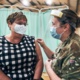 Lady receiving her vaccine from a member of the armed forces