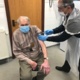 Photograph of Mr Evans receiving vaccine