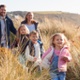 Multi-generational family walking through sand dunes on a sunny autumnal day