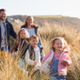 Multi-generational family walking through dunes