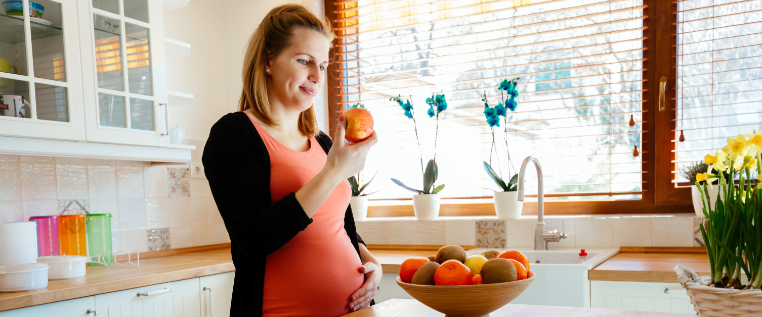 pregnant person holding an apple