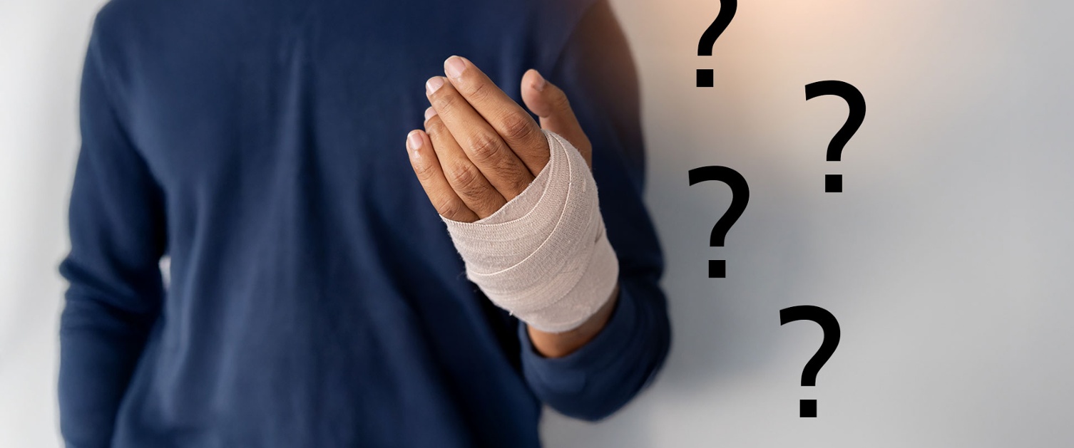 A person has a bandaged hand surrounded by question marks