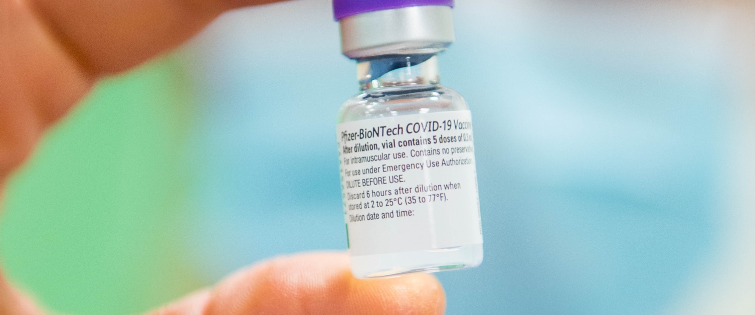 Nurse holding up vaccine vial