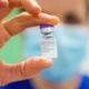 Nurse holding up vaccine vial