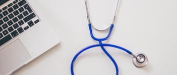 Picture of computer and stethoscope on a white surface