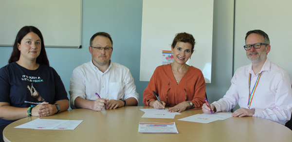 People sitting at table signing paper