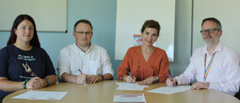 People sitting at table signing paper