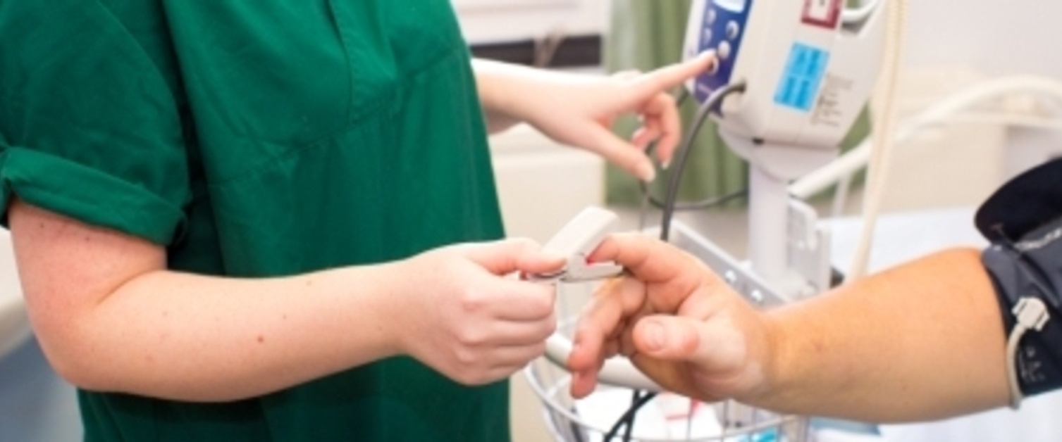 Nurse monitoring pulsation of patient