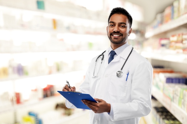 healthcare professional with a lab coat, stethoscope and clipboard in a pharmacy