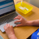 Nurse sat at laptop surrounded by medical equipment for vaccinations