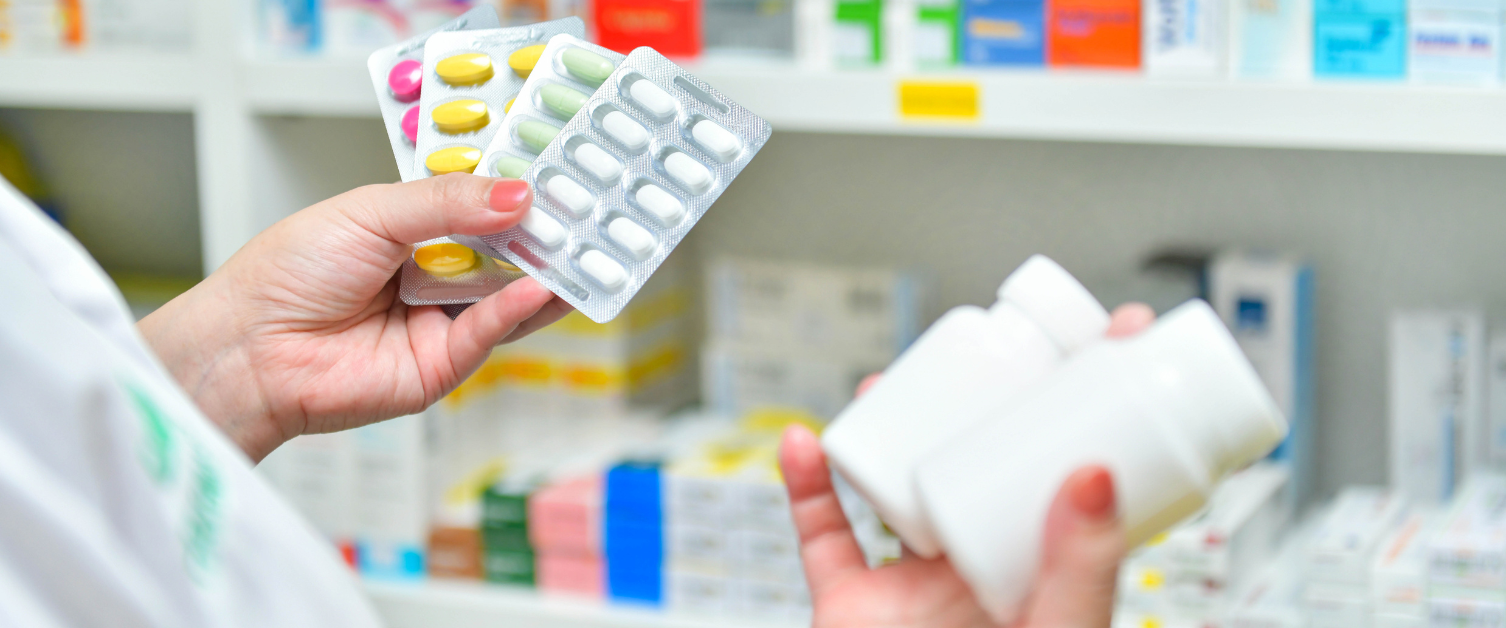 Pharmacist holding medicine pack and medicine bottles