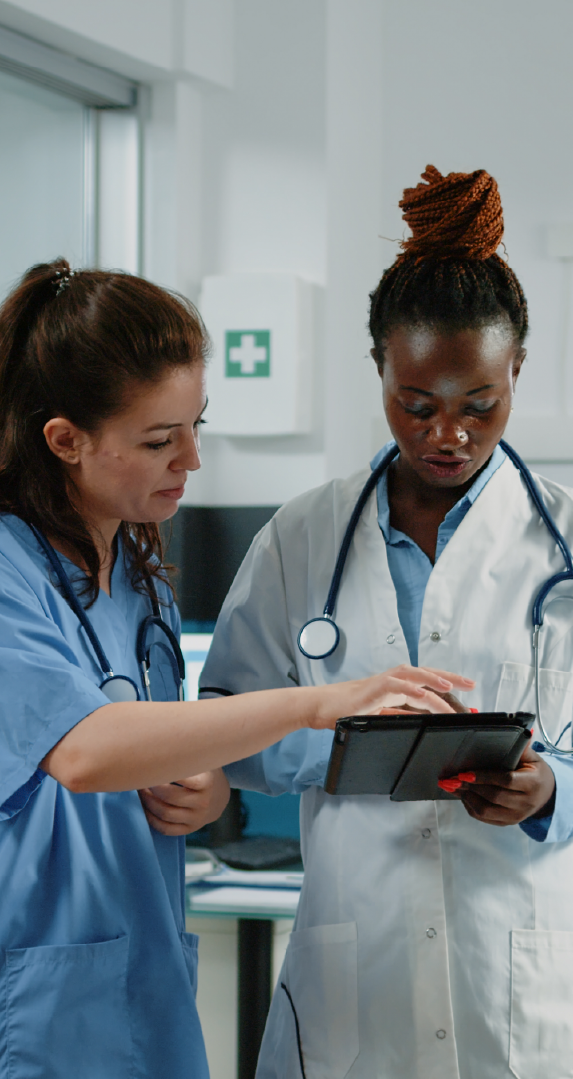Two doctors reviewing information on a tablet and discussing the patient's case